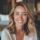 Femme souriante aux cheveux blonds, intérieur cosy.